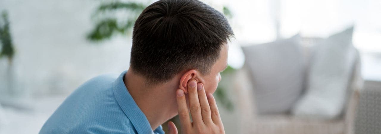 A man holding his ear in pain