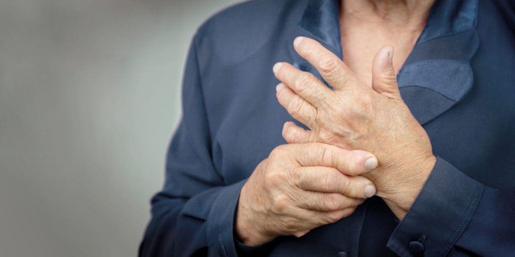 old woman holding and pinching her palm